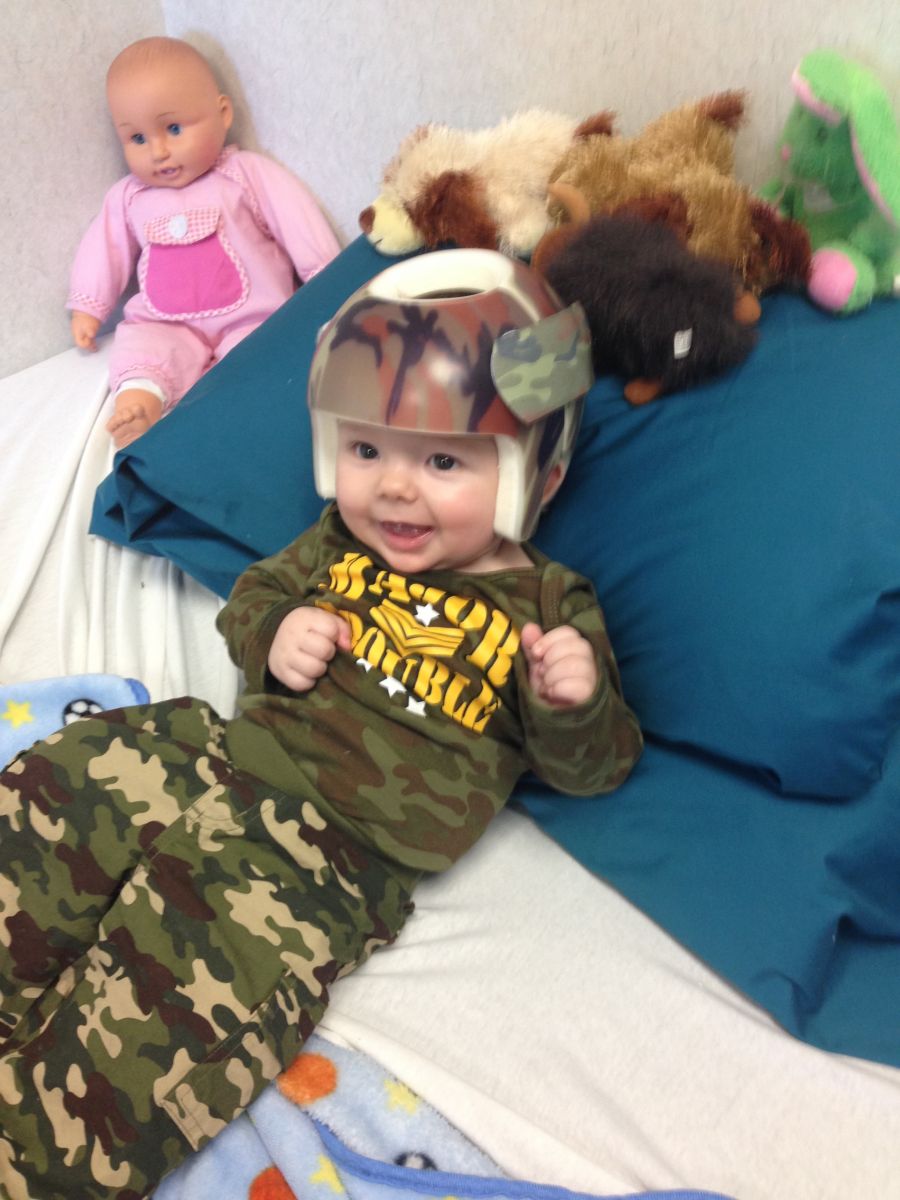 This Is A Photo Of A Child Wearing A Cranial Remodeling Helmet With A Custom Camo Design.