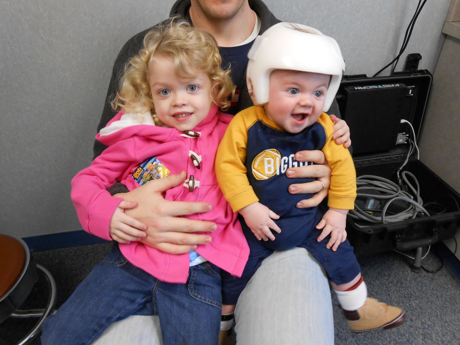 This Is A Photo Of Two Childen, One With A Cranial Remodeling Helmet.